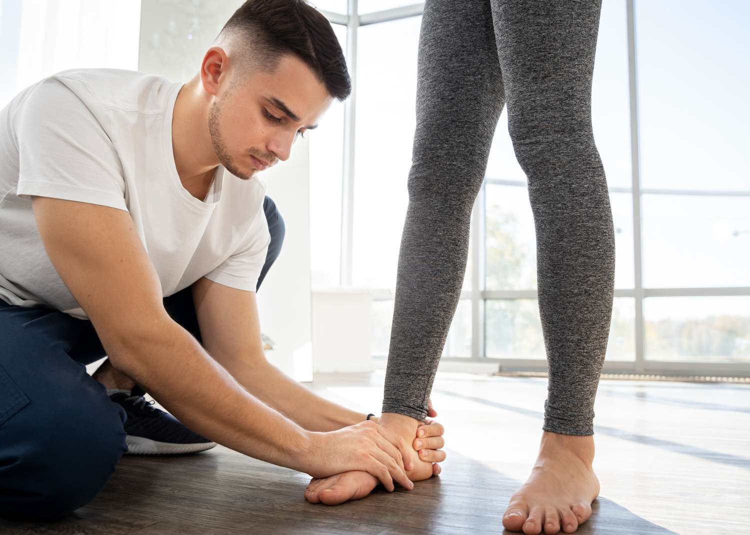 Podiatrist examining a patient’s foot and ankle during a clinical assessment for heel or arch pain.