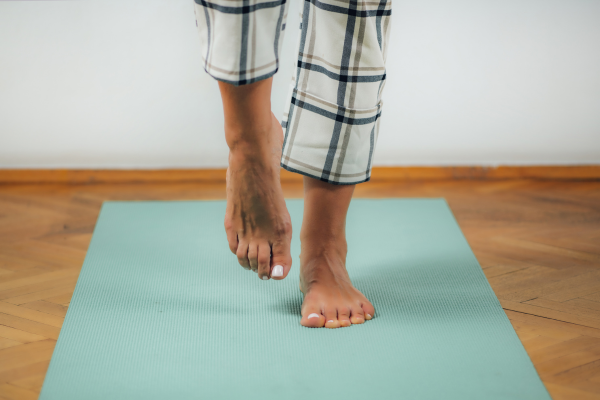 Plantar Fasciitis Stretching Routine — Starting Exercises on a Yoga Mat | Foot & Ankle Centers of New Jersey Bare feet stepping onto a yoga mat, representing the start of a plantar fasciitis stretching and exercise routine on a cushioned surface